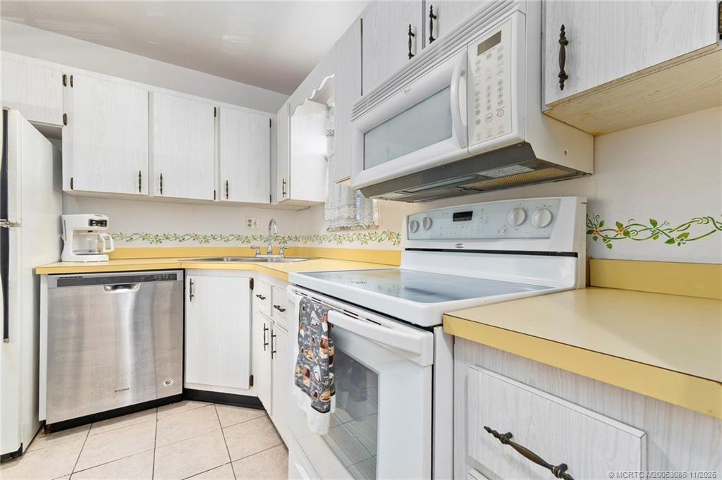 1951 Southwest Palm City Road, Unit 26F Stuart, FL 34994 - Photo 3 of 20 a kitchen with cabinets appliances and a counter space