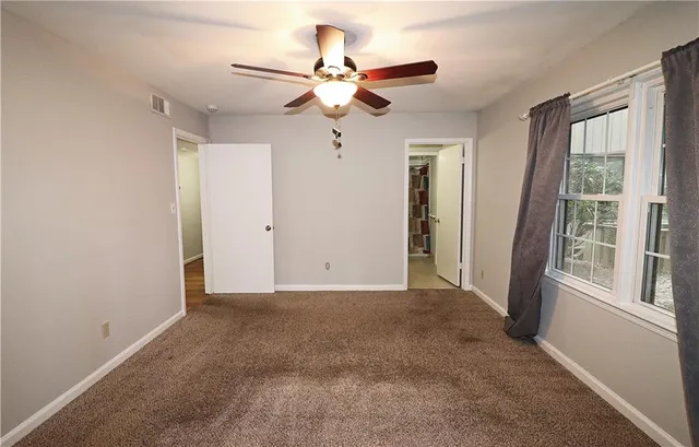 a view of room with ceiling fan and window