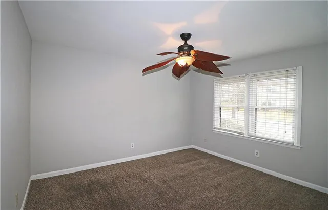 a view of a room with a ceiling fan and window