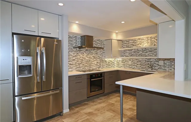 a kitchen with stainless steel appliances granite countertop a refrigerator a sink and a stove