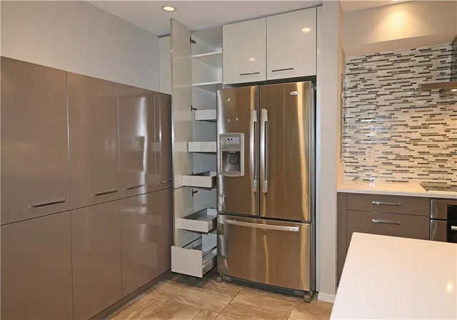 a metallic refrigerator freezer sitting in a kitchen