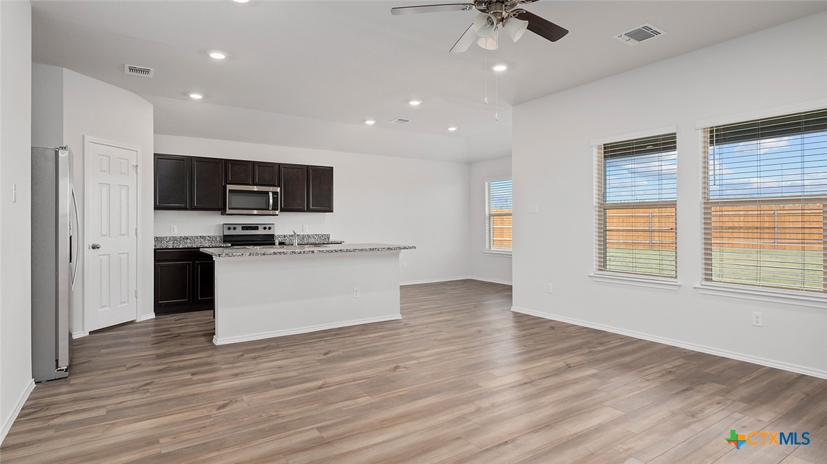 2317 Saffron Road Temple, TX 76501 - Photo 11 of 22 a view of kitchen with microwave a stove and wooden floor