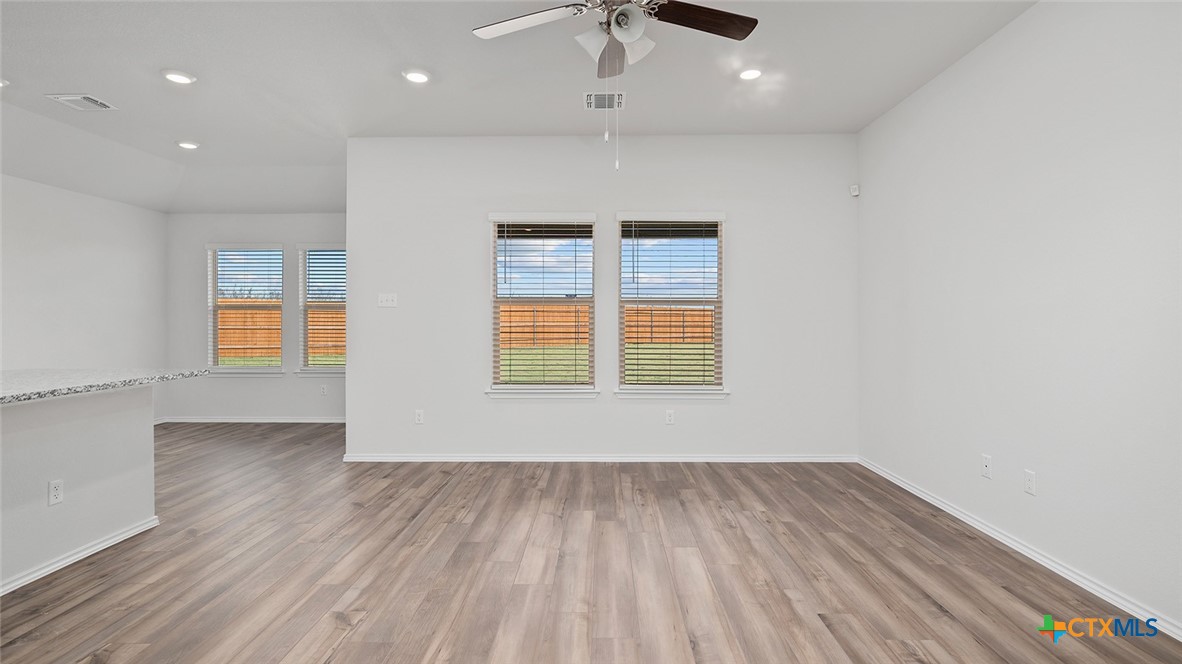 2317 Saffron Road Temple, TX 76501 - Photo 12 of 22 an empty room with wooden floor cabinet and windows