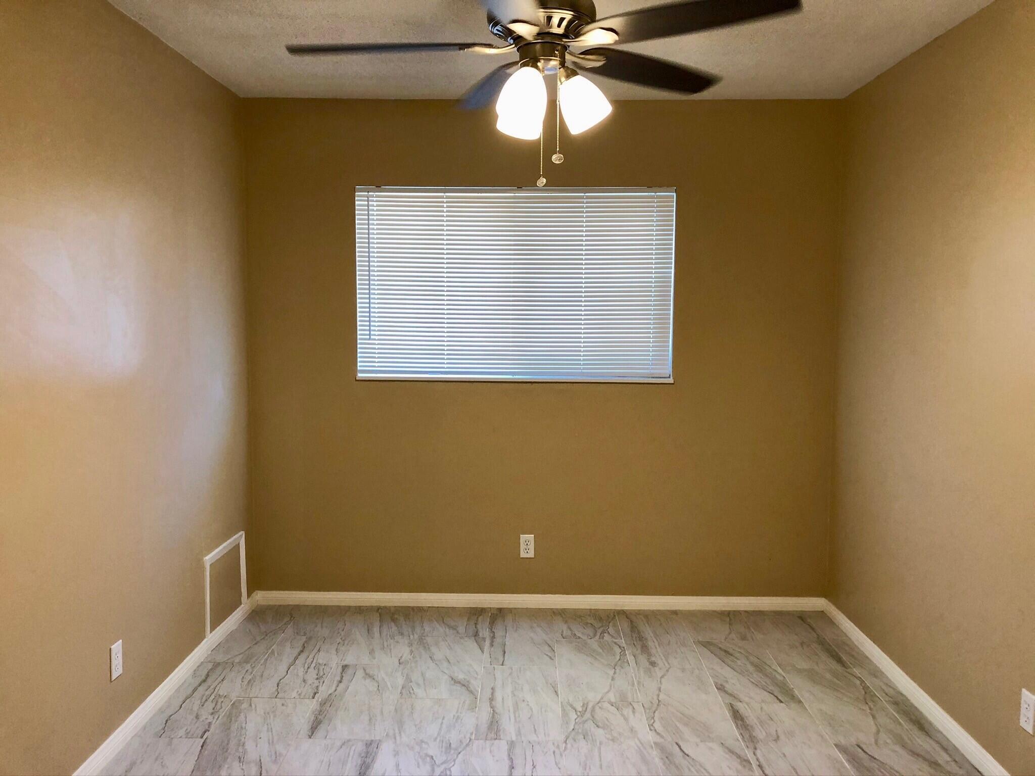 81104 Francis Avenue Indio, CA 92201 - Photo 15 of 23 an empty room with a window and a chandelier fan