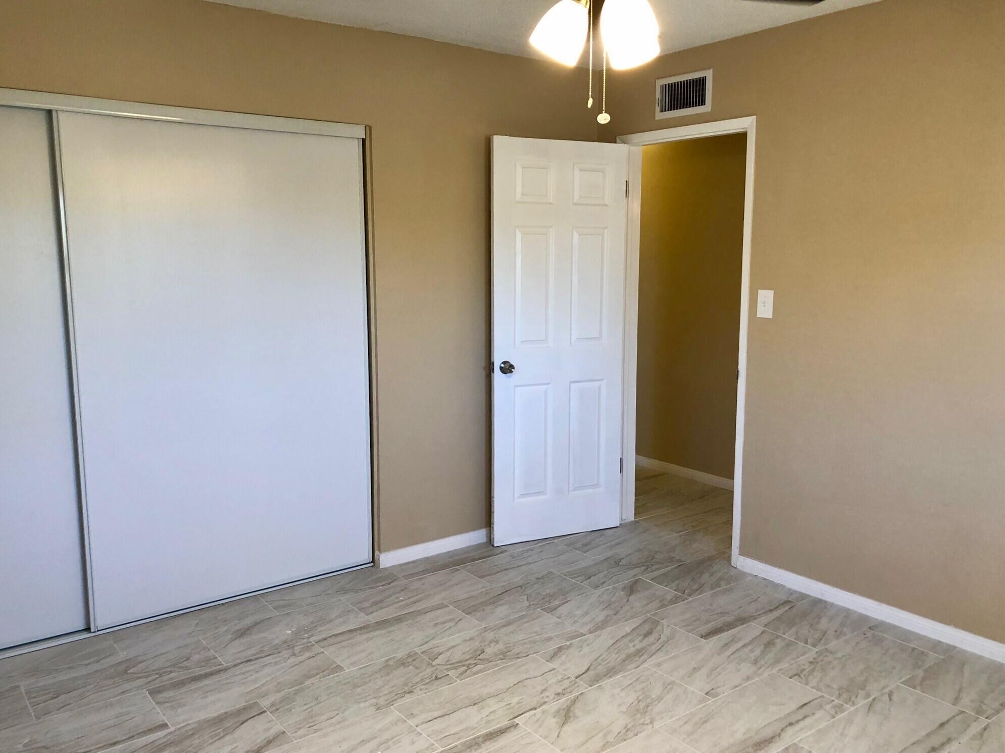 81104 Francis Avenue Indio, CA 92201 - Photo 17 of 23 an empty room with wooden floor a chandelier fan and closet area
