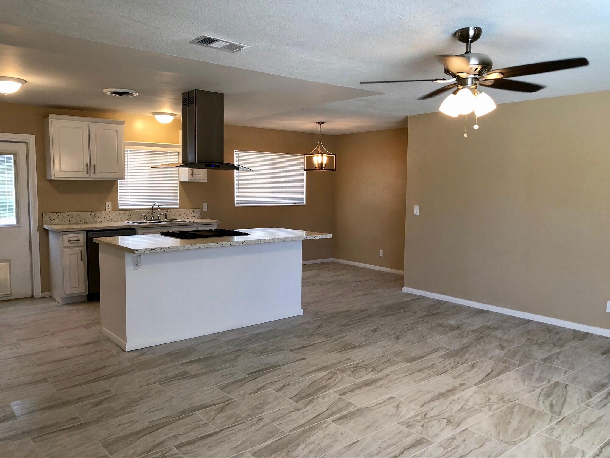 81104 Francis Avenue Indio, CA 92201 - Photo 4 of 23 a kitchen with kitchen island a counter top a stove and a ceiling fan