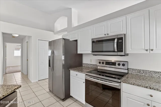 a kitchen with stainless steel appliances white cabinets and a stove top oven