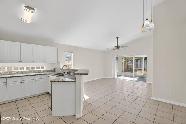 a kitchen with granite countertop white cabinets and white appliances