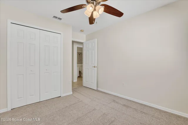 an empty room with chandelier fan