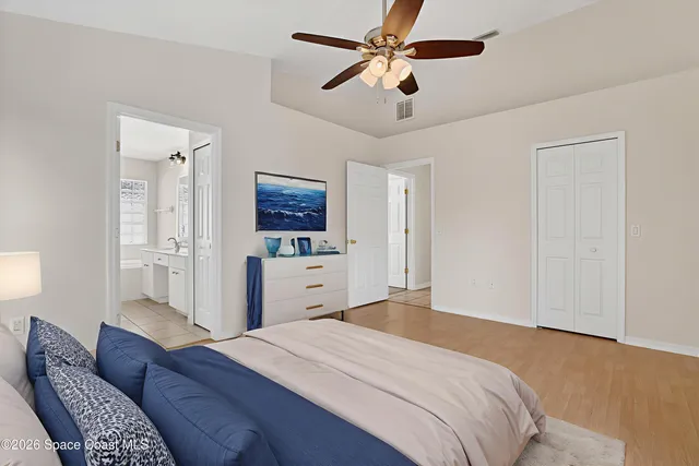 a bedroom with a bed dresser and a flat tv screen