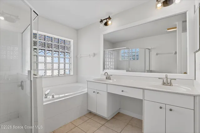 a bathroom with a tub sink shower and mirror