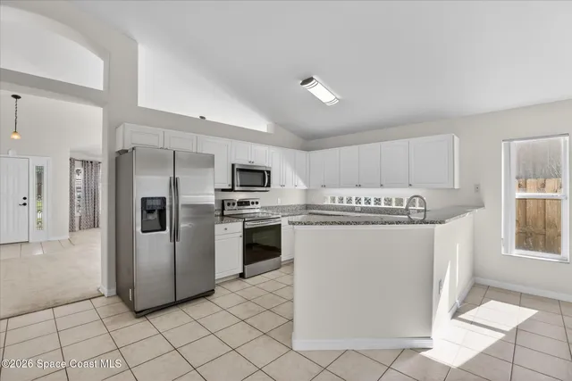 a kitchen with stainless steel appliances granite countertop a refrigerator sink and stove