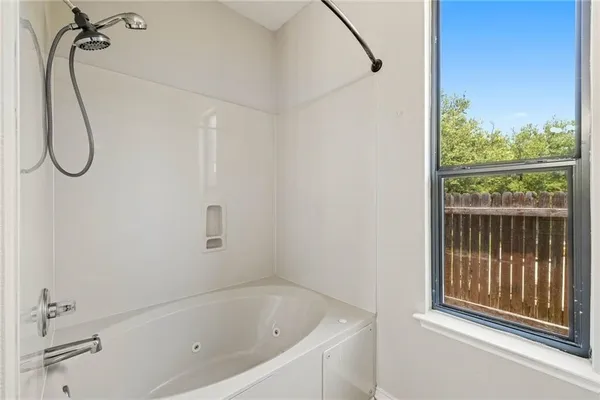 a bathroom with a double vanity sink a mirror a bathtub and shower