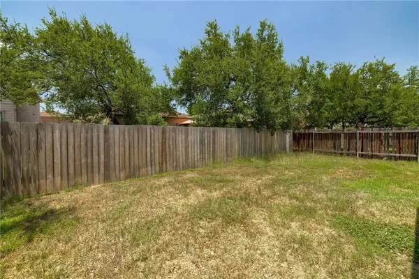 a backyard of a house with lawn chairs and wooden fence