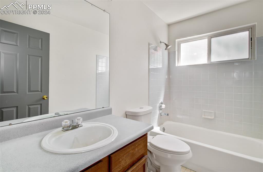 4176 South Himalaya Way Aurora, CO 80013 - Photo 14 of 27 Full bathroom featuring tiled shower / bath combo, toilet, and vanity