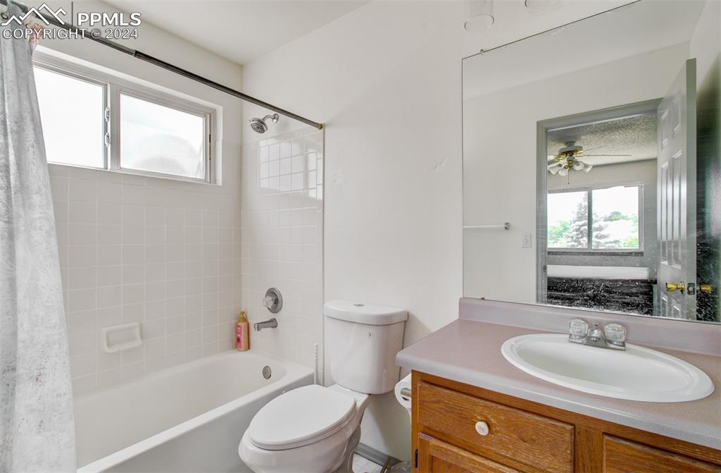 4176 South Himalaya Way Aurora, CO 80013 - Photo 15 of 27 Full bathroom with vanity, shower / bath combo with shower curtain, ceiling fan, and toilet