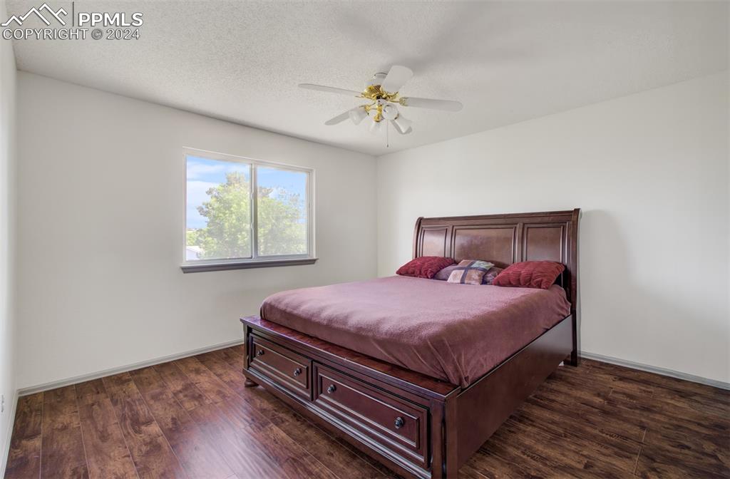 4176 South Himalaya Way Aurora, CO 80013 - Photo 16 of 27 Bedroom with dark hardwood / wood-style flooring, a textured ceiling, and ceiling fan
