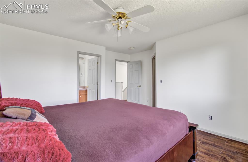 4176 South Himalaya Way Aurora, CO 80013 - Photo 17 of 27 Bedroom with ensuite bath, dark wood-type flooring, and ceiling fan
