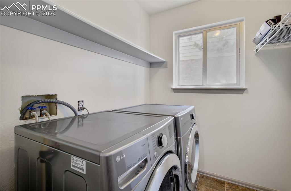 4176 South Himalaya Way Aurora, CO 80013 - Photo 23 of 27 Laundry room with separate washer and dryer and dark tile patterned flooring