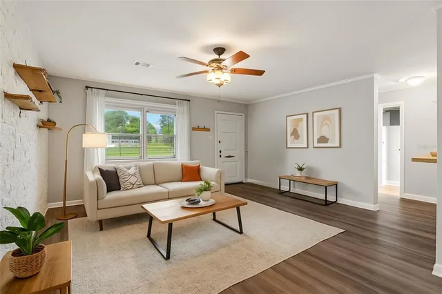 a view of a livingroom with wooden floor and a ceiling fan