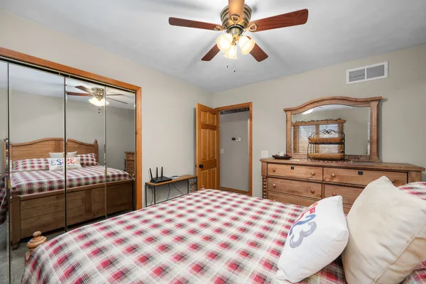 a bedroom with a bed and a large mirror