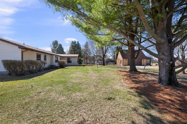 a view of a house with backyard and a tree