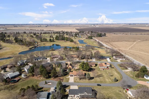 an aerial view of ocean and residential houses with outdoor space