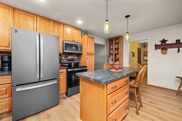 a kitchen with stainless steel appliances granite countertop a refrigerator a stove top oven a sink and a refrigerator