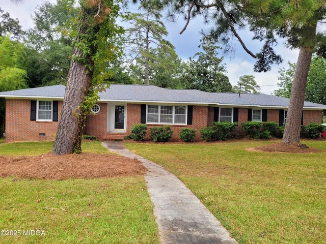 a front view of a house with a yard and trees
