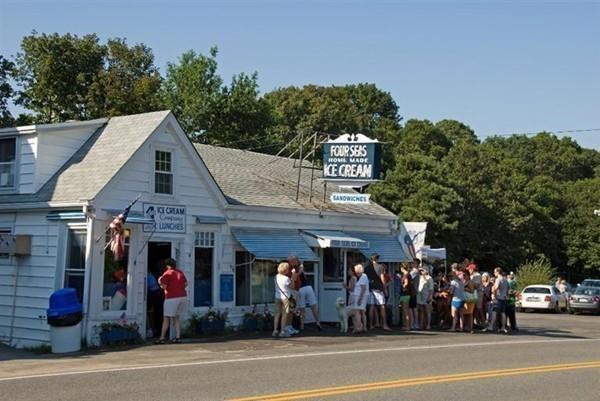 3 Kalmia Way Barnstable, MA 02632 - Photo 26 of 26 a group of people sitting on a sidewalk in front of retail shop