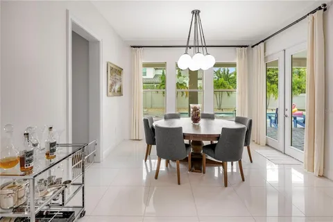 a room with a table chairs and a window