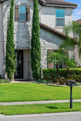 a view of a dining room with furniture large windows a chandelier and kitchen view