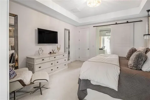 a spacious bedroom with a bed and wooden floor