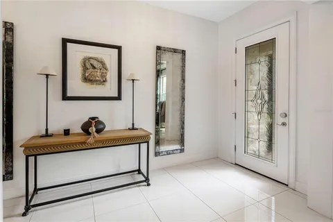 a living room with furniture floor to ceiling window hardwood floor and a flat screen tv