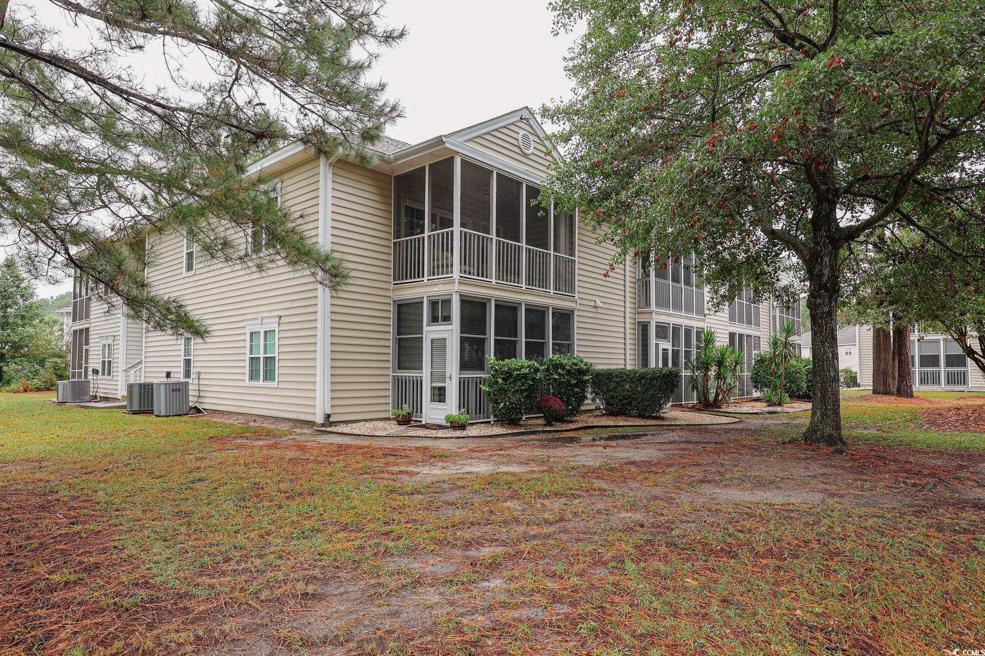 2302 Sweetwater Boulevard, Unit 2302 Murrells Inlet, SC 29576 - Photo 3 of 24 Rear view of property with a sunroom, a balcony, and a lawn
