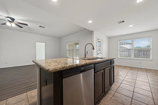 a kitchen with granite countertop a sink cabinets and window