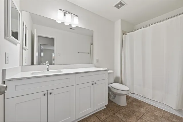 a bathroom with a double vanity sink mirror and toilet