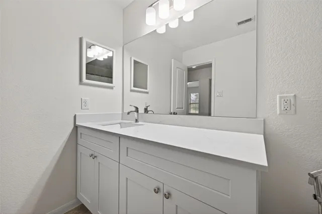 a bathroom with a sink a large mirror and vanity