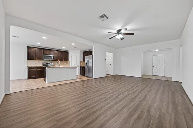a view of kitchen with microwave a stove and wooden floor