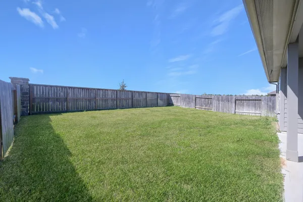 a view of yard with swimming pool and wooden fence