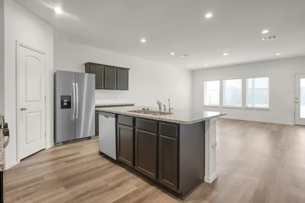 a kitchen with stainless steel appliances granite countertop a refrigerator and a sink