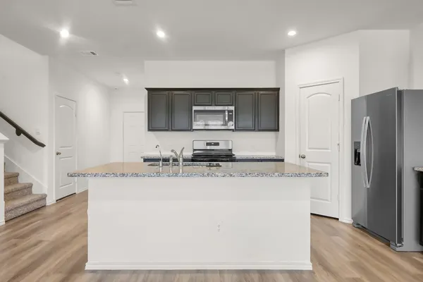 a kitchen with stainless steel appliances granite countertop a sink stove and refrigerator