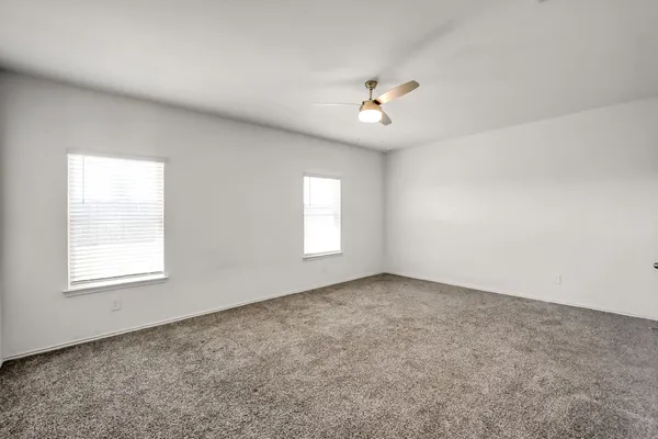 an empty room with a window and a ceiling fan