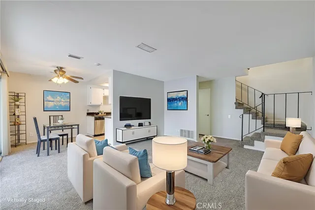 a living room with furniture a flat screen tv and a dining table