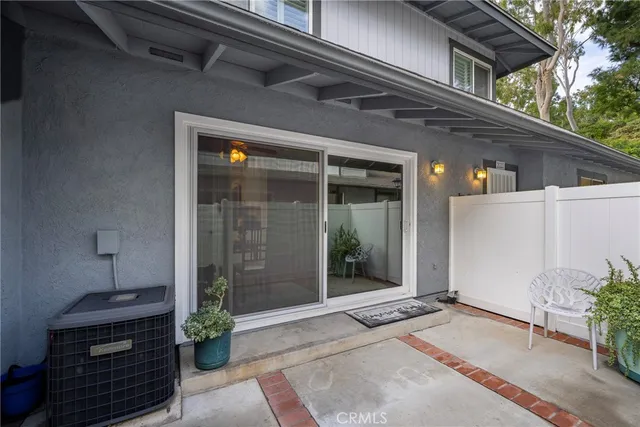 a view of a backyard with lawn chairs plants and large tree
