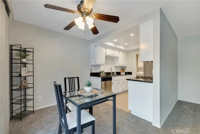 a kitchen with stainless steel appliances granite countertop a stove a refrigerator a kitchen island a sink dishwasher a stove and white cabinets with wooden floor