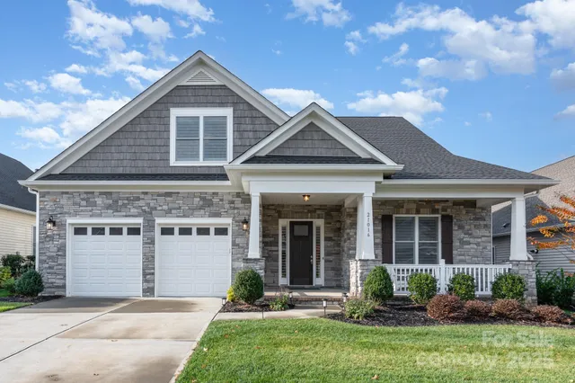 a front view of a house with a yard and potted plants