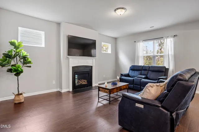 a living room with furniture a fireplace and a window