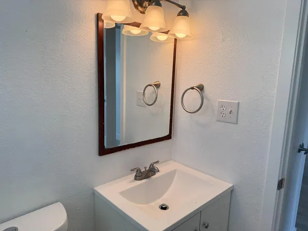 a bathroom with a toilet sink and mirror