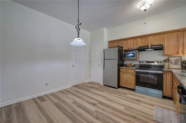 a kitchen with stainless steel appliances a refrigerator and a stove top oven